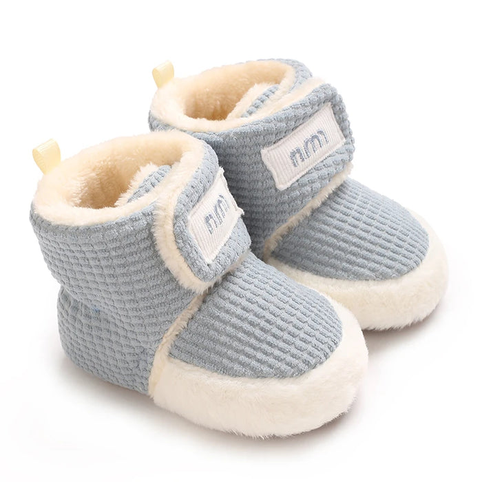 Botinha de Bebê Quentinha Pelúcia Waffle vestida no pezinho do bebê
